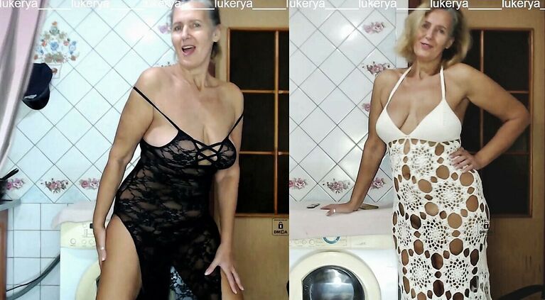 Excited Lukerya tries on long dresses in the kitchen.